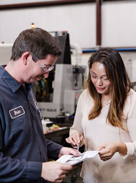 Machinist and engineer reviewing a product design