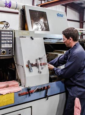 Machinist operating a Swiss CNC turning machine